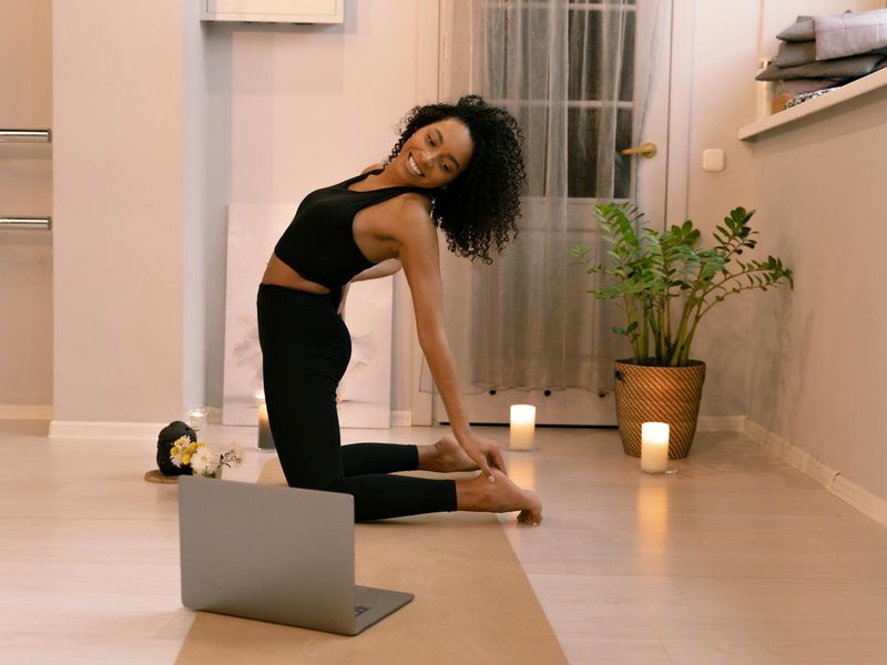 A person performing a balancing yoga pose in a bright room.