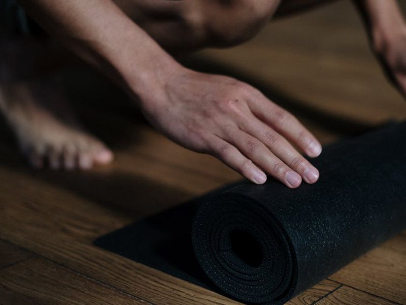 Detailed close-up of yoga mat and accessories on a wooden floor.