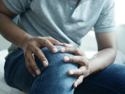 Hands of a person meditatively resting on knees.